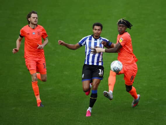 Sheffield Wednesday winger Jacob Murphy and Huddersfield Town rival Trevoh Chalobah tussle for the ball, with Richard Stearman in close attendance.