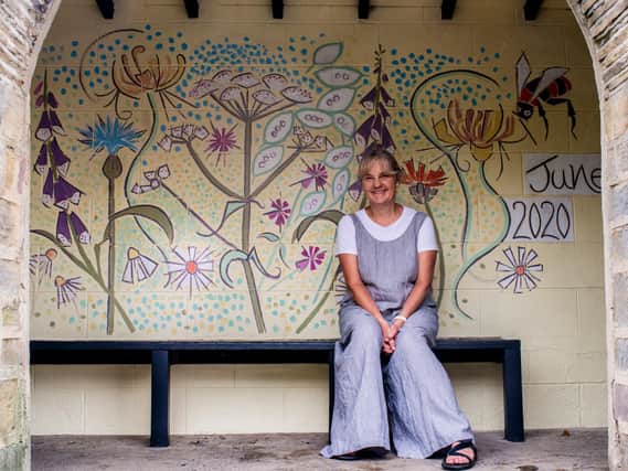 Artist Kim Coley with her bus stop mural. Photo: Ernesto Rogata