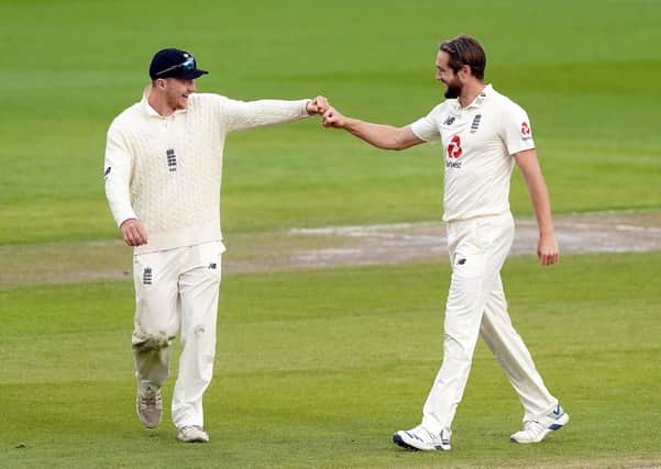 Socially-distanced celebration: England’s Chris Woakes, right, returned the home side’s best bowling figures – 3-42 – but it was not enough to force the West Indies to follow on as they reached 287 all out at Old Trafford. England will resume on today’s fifth day at 37-2 as they bid to level the series (Picture: PA)