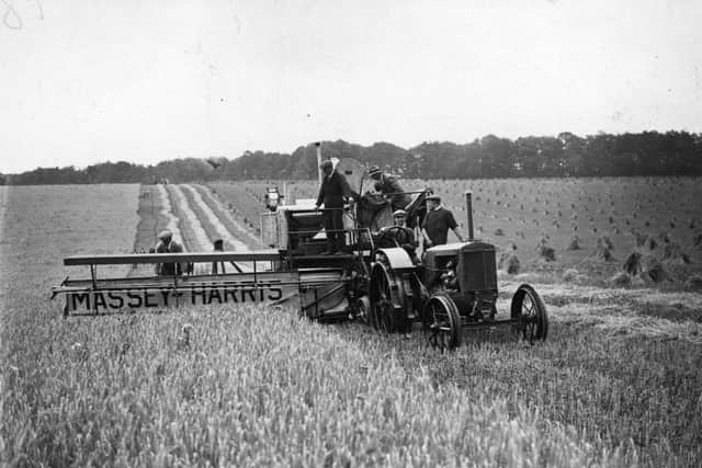 1929:  A combine harvester, cutting and threshing the barley in one action.  (Photo by Topical Press Agency/Getty Images)