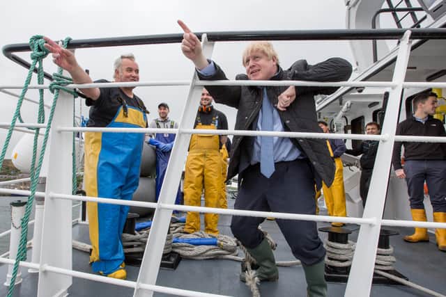 Prime Minister Boris Johnson speaks to members of the crew on the Carvela at Stromness Harbour in Stromness during a visit to the Highlands and Northern Isles of Scotland.