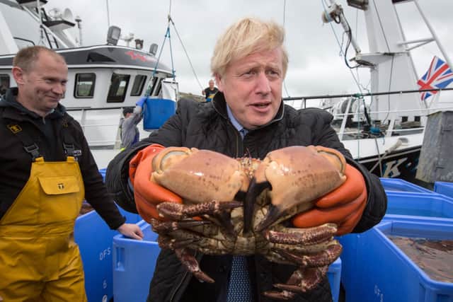 Prime Minister Boris Johnson holds crabs caught on the Carvela with Karl Adamson at Stromness Harbour  in Stromness during a visit to the Highlands and Northern Isles of Scotland.