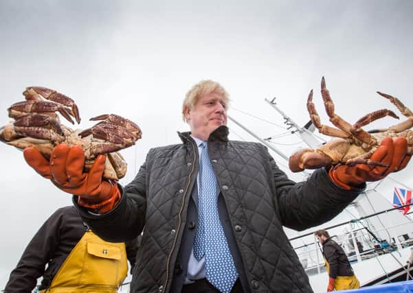Prime Minister Boris Johnson holds crabs caught on the Carvela at Stromness Harbour  in Stromness during a visit to the Highlands and Northern Isles of Scotland.