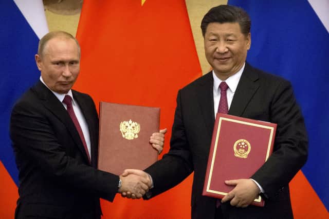Russian President Vladimir Putin, left, and Chinese President Xi Jinping shake hands during a signing ceremony at the Great Hall of the People in Beijing, but which leader poses the greatest threat to Britain?