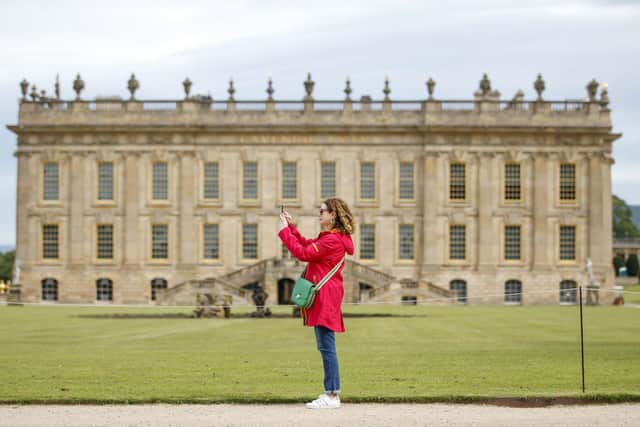 A woman takes a photograph in the grounds of Chatsworth House in Bakewell, Derbyshire, which reopens to the public on Monday after the lifting of further coronavirus lockdown restrictions in England. PA Photo.
