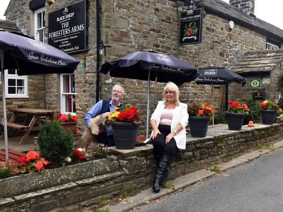 Keith and Lesley Sharpe with Barney the dog outside The Foresters Arms at Carlton in Coverdale.