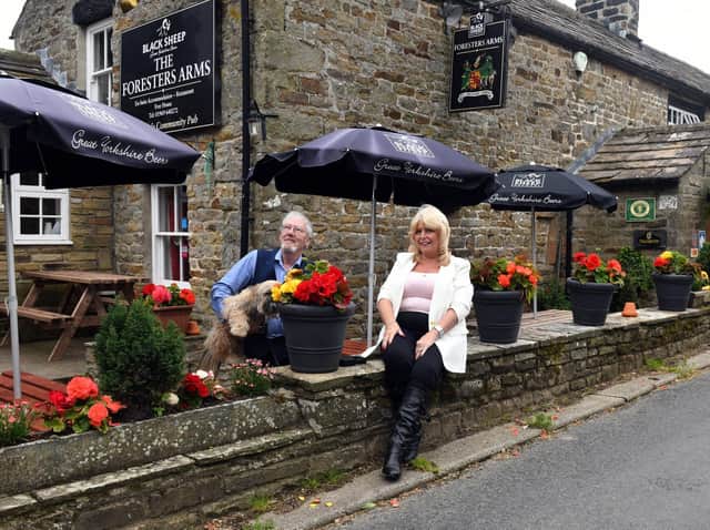 Keith and Lesley Sharpe with Barney the dog outside The Foresters Arms at Carlton in Coverdale.