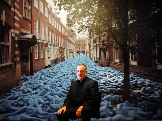 Artist Spencer Tunick pictured with one of his photographs, Sea of Hull, at the Ferens Art Gallery in 2017