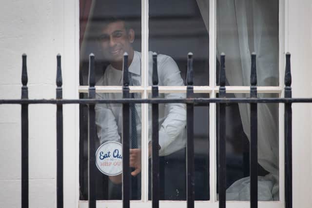 Chancellor Rishi Sunak places an 'Eat out to help out' sticker in the window of No.11 Downing Street in London, ahead of the new scheme encouraging customers to return to the hospitality industry. Picture: Stefan Rousseau/PA Wire