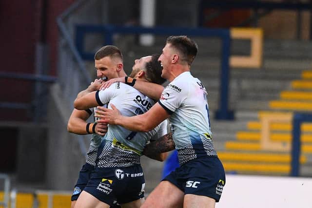 Luke Gale is mobbed by his Leeds Rhinos' team-mates after his golden point drop goal earns a dramatic win over Huddersfield Giants at Headingley. Picture: James Hardisty.