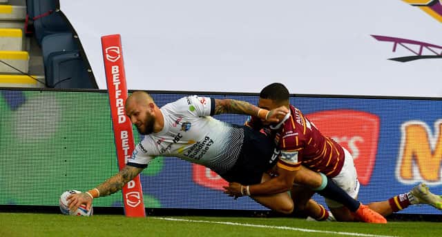 Leeds Rhinos' Luke Briscoe dives in at the corner to score a try despite being tackled by Huddersfield Giants' Darnell Mcintosh. Picture: James Hardisty