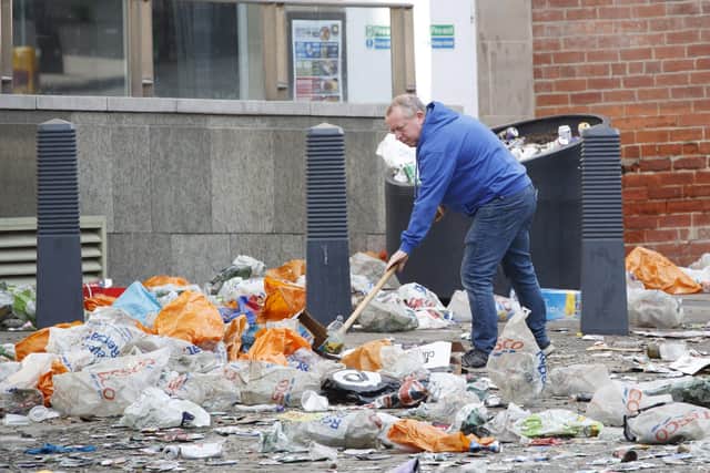Workers clear up litter left by Leeds United fans celebrating the team's promotion to the Premier League.