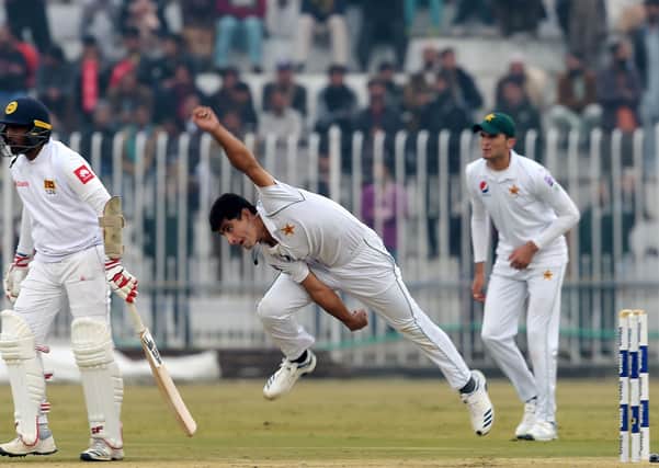 Pakistan's Naseem Shah (C) delivers a ball next to Sri Lanka's Dilruwan Perera (L) as Pakistan's Shaheen Shah Afridi (R) looks on during the third day of the first Test cricket match between Pakistan and Sri Lanka at the Rawalpindi Cricket Stadium in Rawalpindi on December 13, 2019. (Photo by AAMIR QURESHI / AFP) (Photo by AAMIR QURESHI/AFP via Getty Images)
