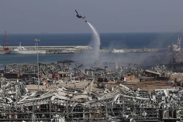 An army helicopter drops water at the scene of Tuesday's massive explosion that hit the seaport of Beirut, Lebanon. (AP Photo/Hussein Malla)
