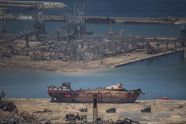 A day after a massive explosion occurred, people walk past a boat that received damages at the port on Aug. 5, 2020 in Beirut, Lebanon. (Photo by Daniel Carde/Getty Images)