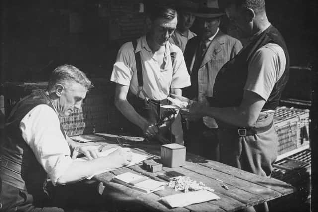 9th July 1935:  Pigeon fanciersstamping and ringing their birds in preparation for the Kings Cup Pigeon Race.  (Photo by Davies/Topical Press Agency/Getty Images)