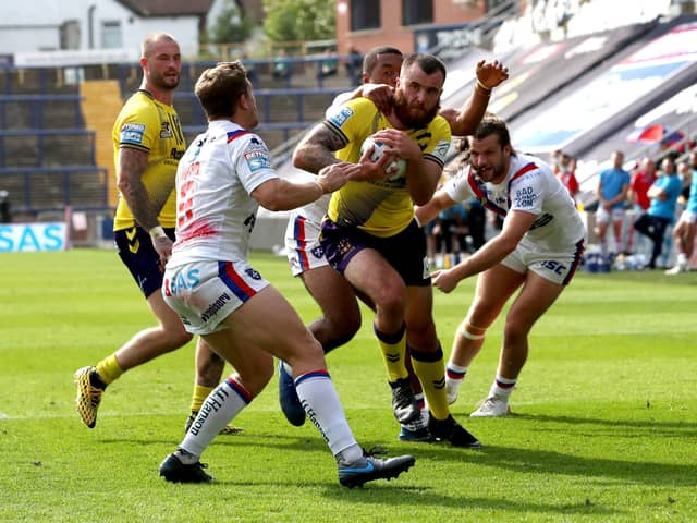 Wigan Warriors' Jake Bibby (second right) goes over for a try against Wakefield. Picture: PA.