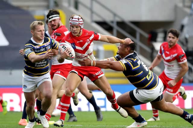 St Helens' Theo Fages (centre) is tackled by Leeds Rhinos' Mikolaj Oledzki (left) and Ava Seumanufagai.