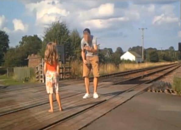 A father takes a photo of his daughter in the middle of the railway line between Driffield and Bridlington