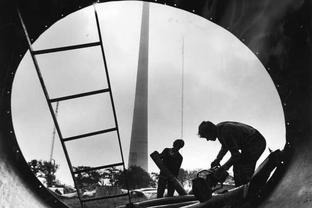 1970:  The new TV mast at Emley Moor, near Huddersfield, soars up through low cloud as John Orton and Derek Miller, framed in the broken section of the old mast start work on cutting up copper and aluminium cable. Work on clearing the wreckage of the old mast, which was brought down by snow and ice, was delayed while the committee of inquiry completed investigations.

Now 'operation Clear-Up' has been given the go ahead and work on clearing the wrecakge as started.
The move has been welcomed by villagers who have had their peace and quiet disturbed, particularly at weekends when souvenir hunters and scrap metal scavengers searched through the ruins of the lattice type mast.