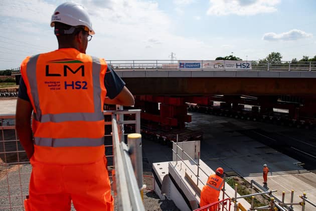 HS2 workers watch as a bridge is wheeled into position over the M42 at the HS2 Interchange station site near Solihull as part of the HS2 building works.