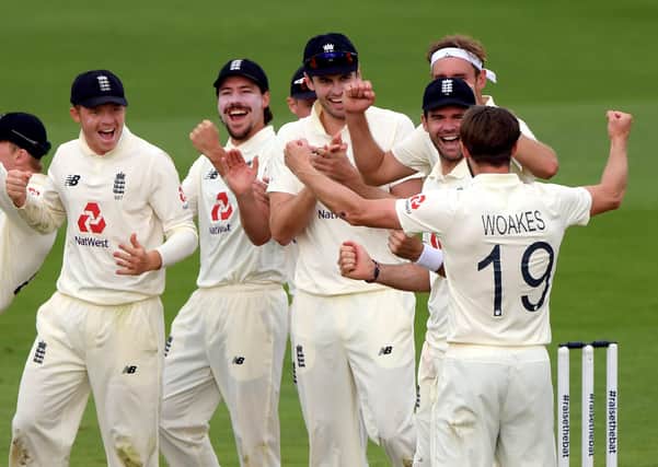 England's Chris Woakes celebrates with his team-mates after their review awards his LBW wicket of Pakistan's Fawad Alam in their favour.