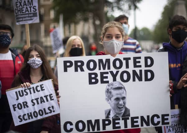 Students wearing face masks take part in a protest in Westminster in London over the government's handling of A-level results, university provision and bleak employment prospects.