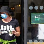 A woman wearing a face mask leaves Starbucks.