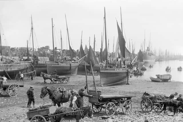 A busy Newlyn harbour crowded with boats and carts