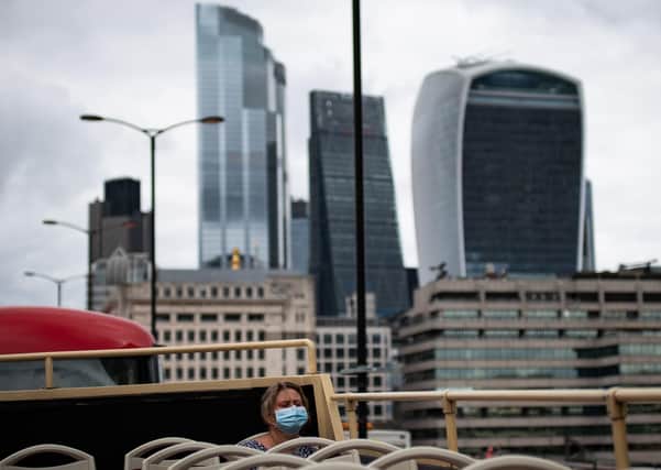 Tourists on a near empty top deck on the London Big Bus open-top tour as it passes the city of London on August 23. Picture: Aaron Chown/PA Wire