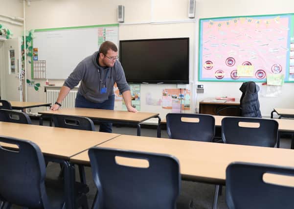 Desks are moved in a classroom as schools prepare to reopen next week.