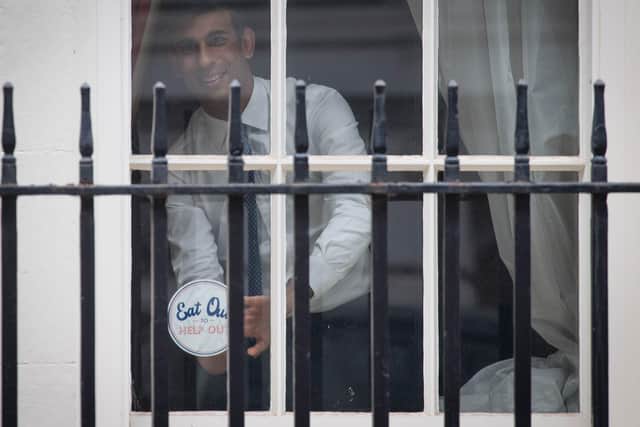 The Chancellor places a 'Eat Out to Help Out' sticker in a window of the Treasury.
