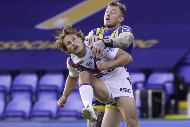 Closed down: Wakefield's Jacob Miller is hit by Warrington's Josh Charnley as he clears the ball downfield. Picture by Allan McKenzie/SWpix.com.