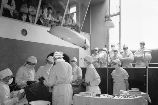circa 1935:  Medical students watch an operation in progress from the gallery at University College Hospital, London.  (Photo by General Photographic Agency/Getty Images)