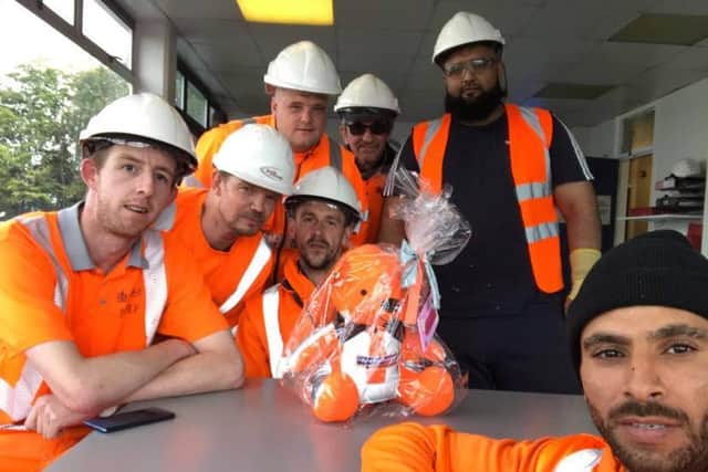 Staff at the recycling plant on Bowling Back Lane in Bradford with the bear made to be buried with the stillborn baby found at the site. The staff have named the little girl 'Daisy'.