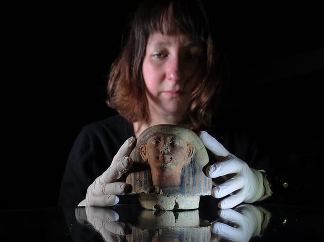 Curator of archaeology Martha Jasko-Lawrence with a              Canopic jar lid. Photo: Simon Hulme