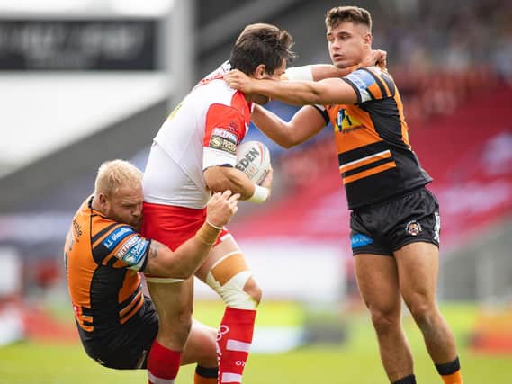 Louie McCarthy-Scarsbrook of St Helens is tackled by Jacques ONeill, right, and Oliver Holmes of Castleford Tigers. (Isabel Pearce/SWpix.com)