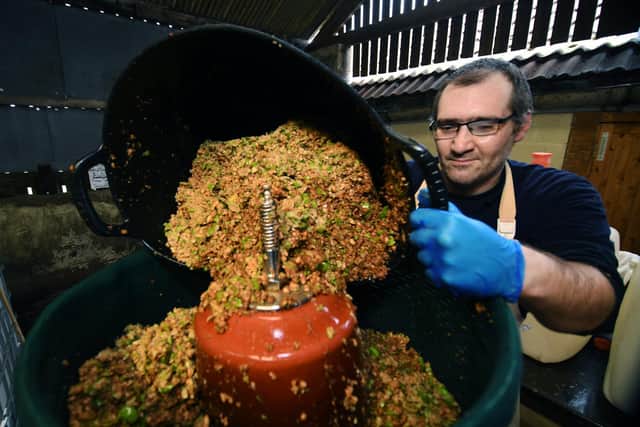 Andreas Machimaris pours crushed apples into the press at Orchards of Husthwaite, near Thirsk.