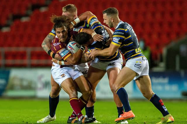Familiar foe: Huddersfield's former Leeds three-quarter Ashton Golding is held by the Rhinos defence.
  Picture Bruce Rollinson