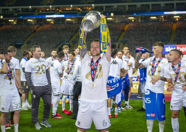 Liam Cooper lifts the championship trophy at Elland Road, winning the division and promoted to the Premier League . (Picture: Tony Johnson)