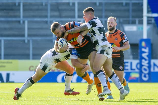 Wrapped up: 
Tigers' Mike McMeeken is held by the Hull defence. Picture Tony Johnson