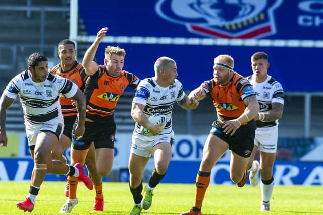 On the move: Hull's Jamie Shaul sprints away from Tigers' Michael Shenton and Oliver Holmes. Picture Tony Johnson