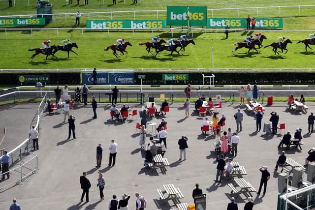 Racegoers look on as Latest Generation ridden by jockey William Buick wins the British Stallion Studs EBF Maiden Stakes as a pilot scheme for the return of crowds to sporting events is expected to bring in 2500 spectators during day one of the William Hill St Leger Festival at Doncaster Racecourse. But those plans had to be abandoned (Picture: PA)