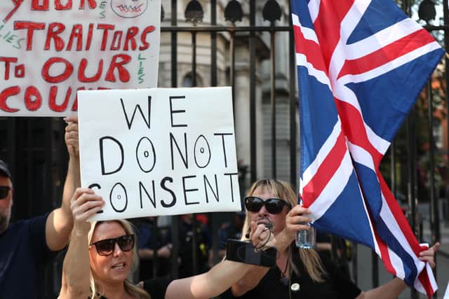 People mount a small protest outside Downing Street in London as the "rule of six" coronavirus regulations come into effect in England. PA Photo. Picture date: Monday September 14, 2020. Police will be expected to exercise their discretion in enforcing the "rule of six" coronavirus regulations.
