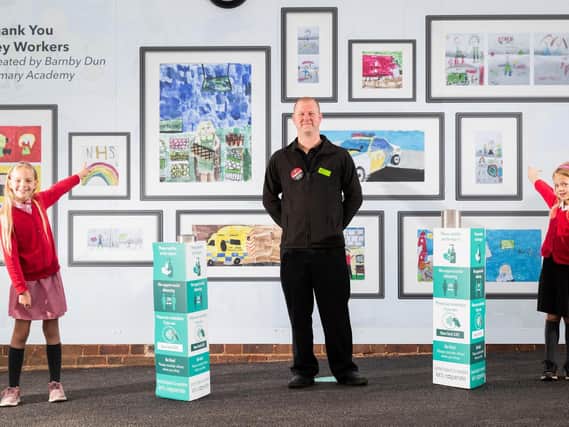 (Pictured from left) Barnby Dun Primary Academy pupils Evelyn Bowman, nine, and Martha Bowman, six, survey the school's artwork which pays tribute to key workers with Store Manager Neil Holmes at the launch of the Barnby Dun store.