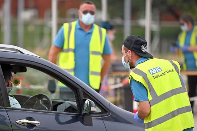 Workers wear NHS Test and Trace branded hi-vis jackets as they work at a COVID-19 testing centre in Bolton. Picture: Getty