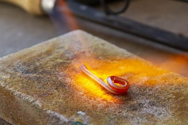 Jewellery maker Mark Bell forms the molten gold into a bar before working into aring shape. Picture Tony Johnson