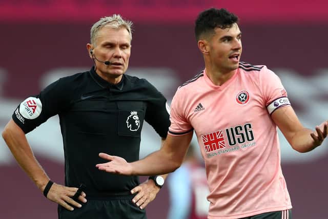 Sheffield United defender John Egan reacts in front of referee Graham Scott as he receives a red card at Villa Park. Picture: Clive Rose/POOL/AFP via Getty Images