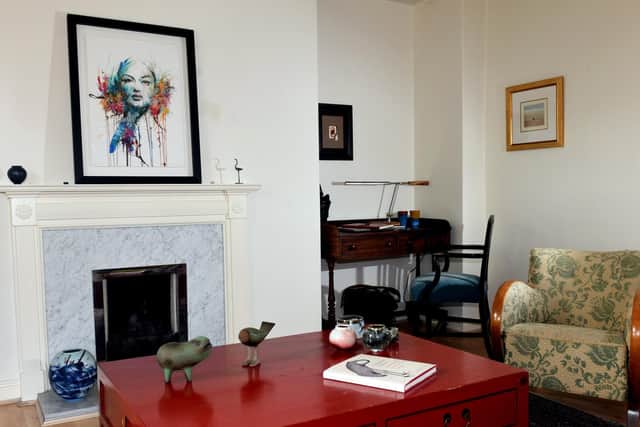 The red oriental coffee table is one of Nick's favourites, along with the Georgian desk, which he bought for £10 at an auction. The picture above the fireplace is by Carne Griffiths.