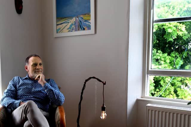 Nick in his sitting room with painting by Norfolk-based Daniel Cole